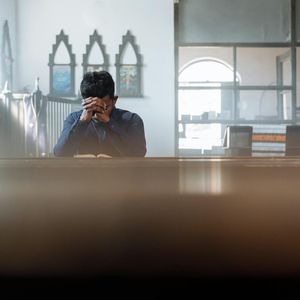 Hands folded in a mudra position during meditation.
