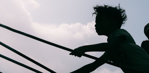 Silhouetted figure moving gracefully in a dark room.